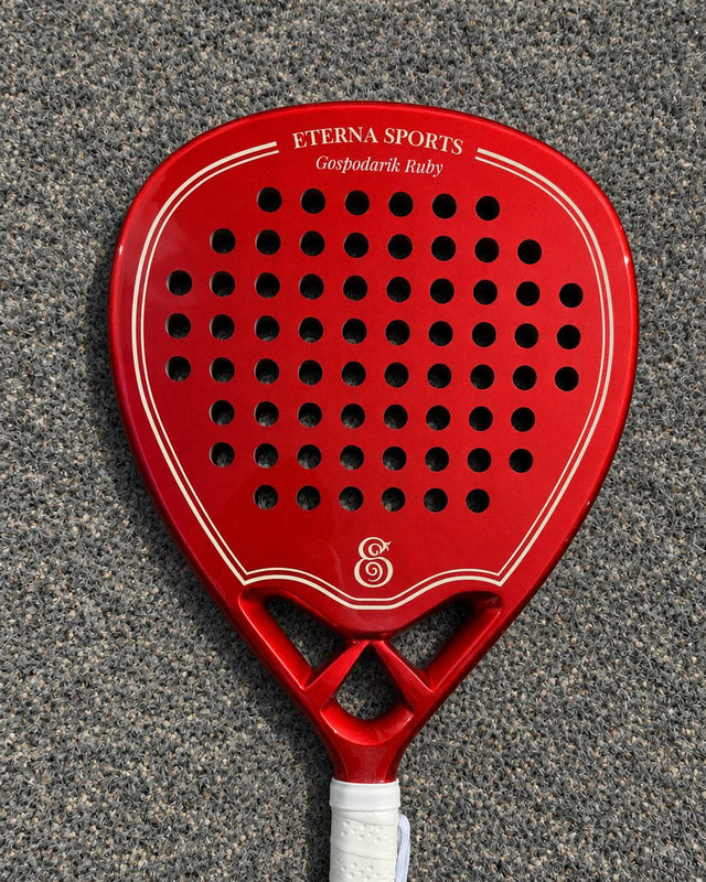 Monaco Red padel racket engraved with the owner's name on the Crown, on a grey court