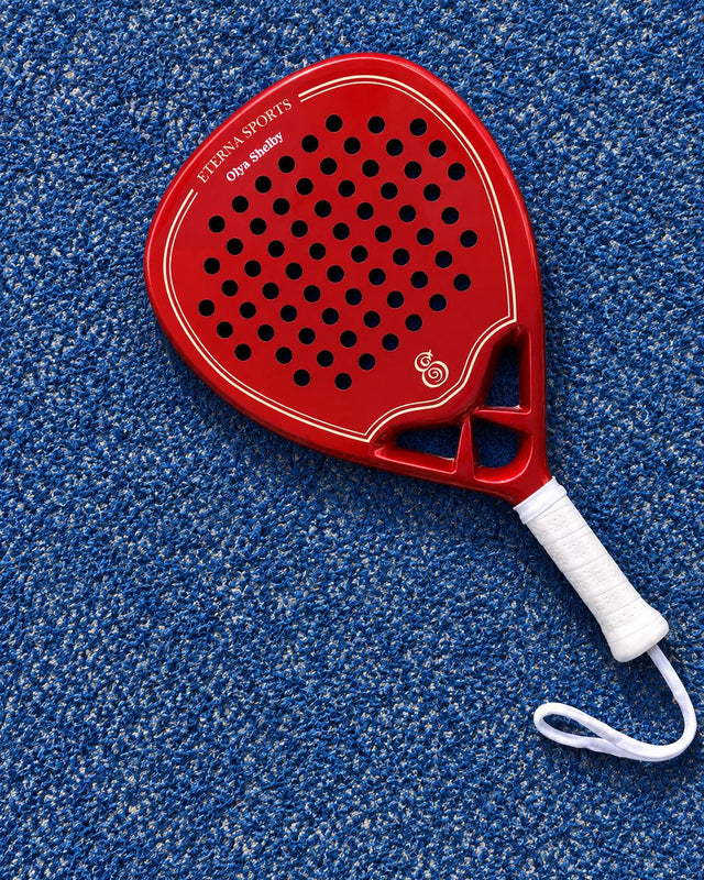 Monaco Red padel racket engraved with the owner's name on the Crown, on a blue court