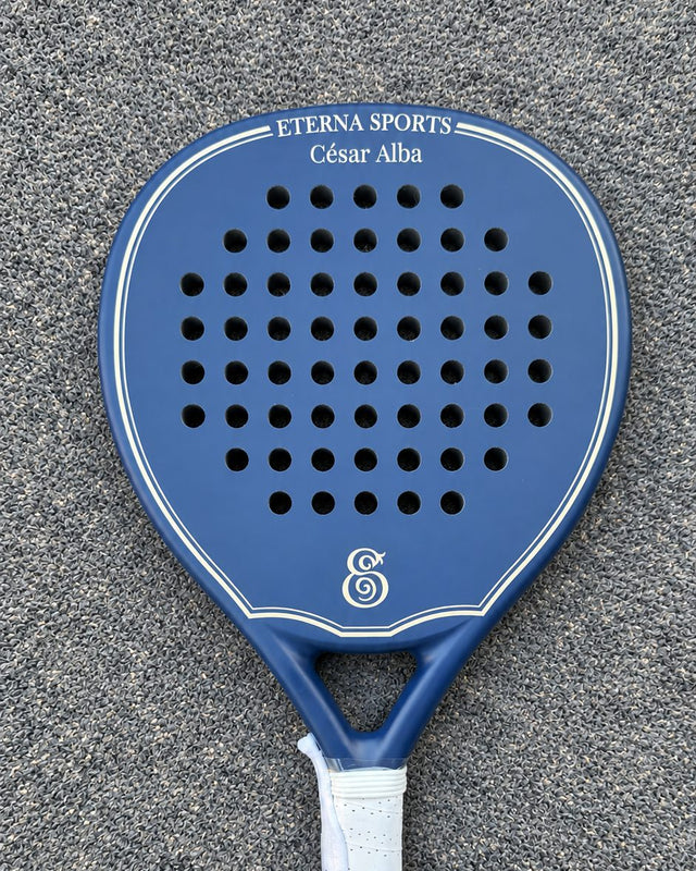 Soho Blue Matte padel racket engraved with the owner's name on the Crown, on a grey court