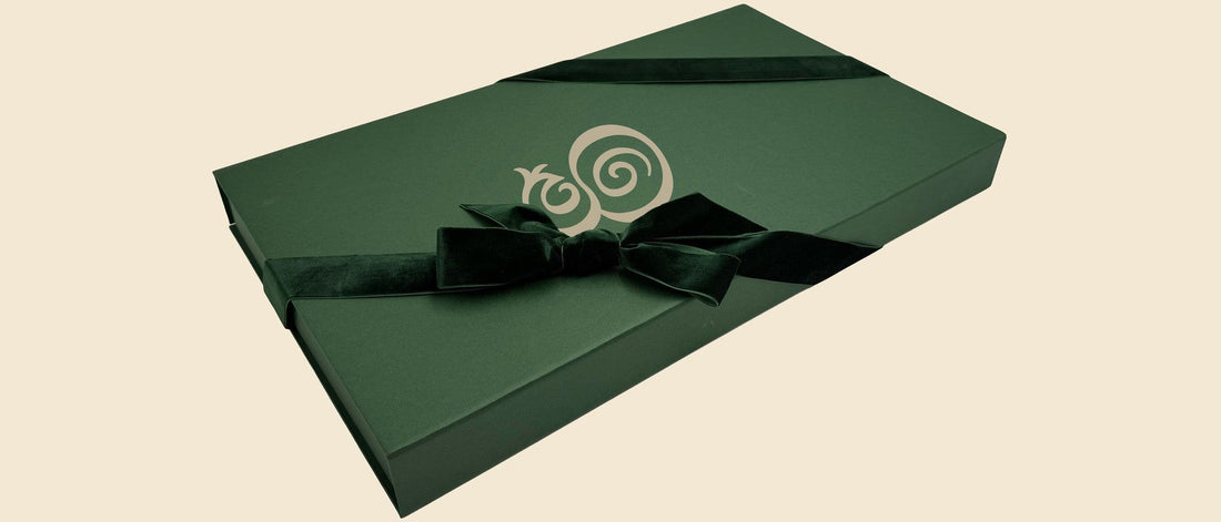 The Eterna gift box in hunter green, monogram in cream, tied with a velvet ribbon