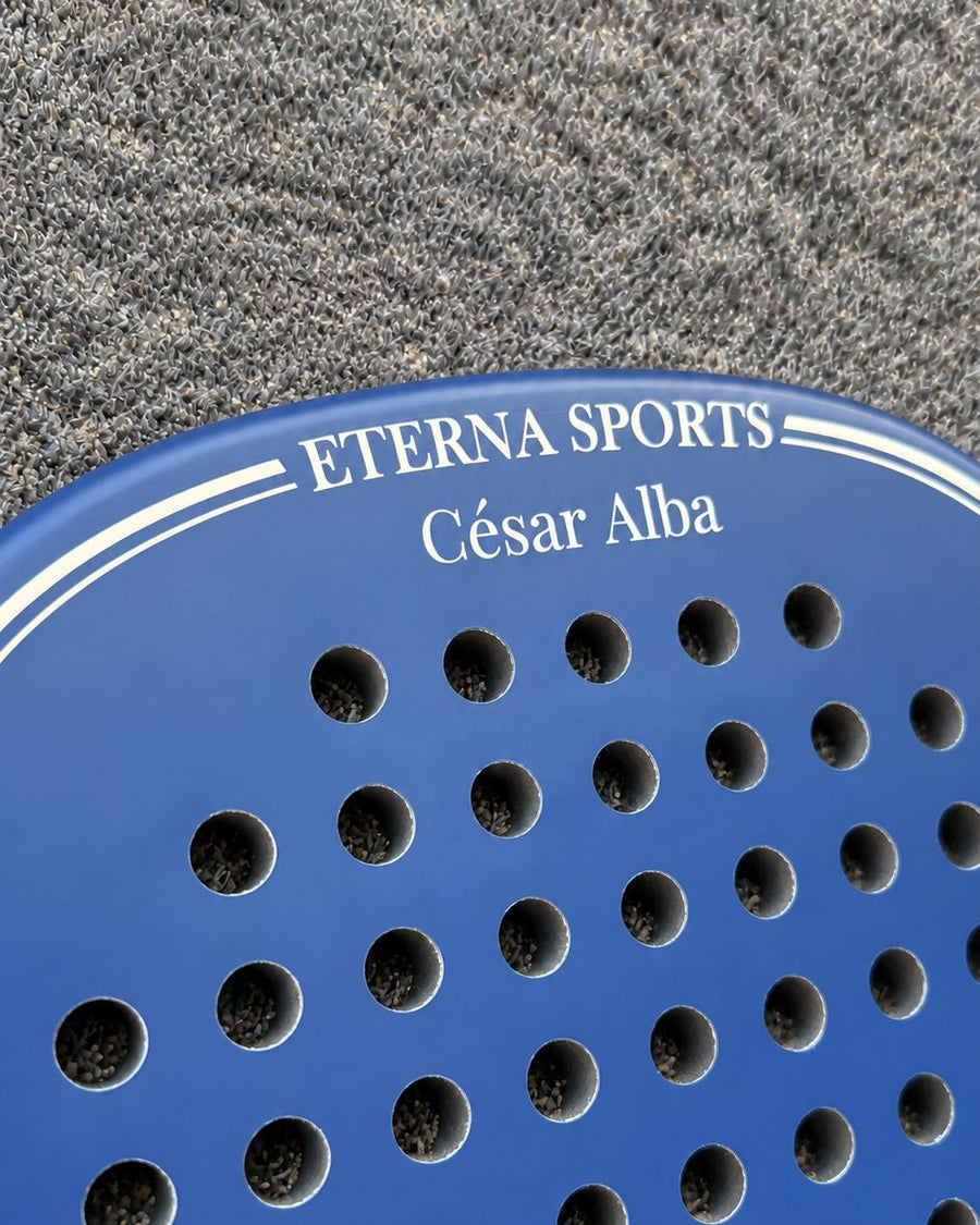 A name engraved on the Crown of a Soho Blue padel racket, below the Eterna Sports lettering
