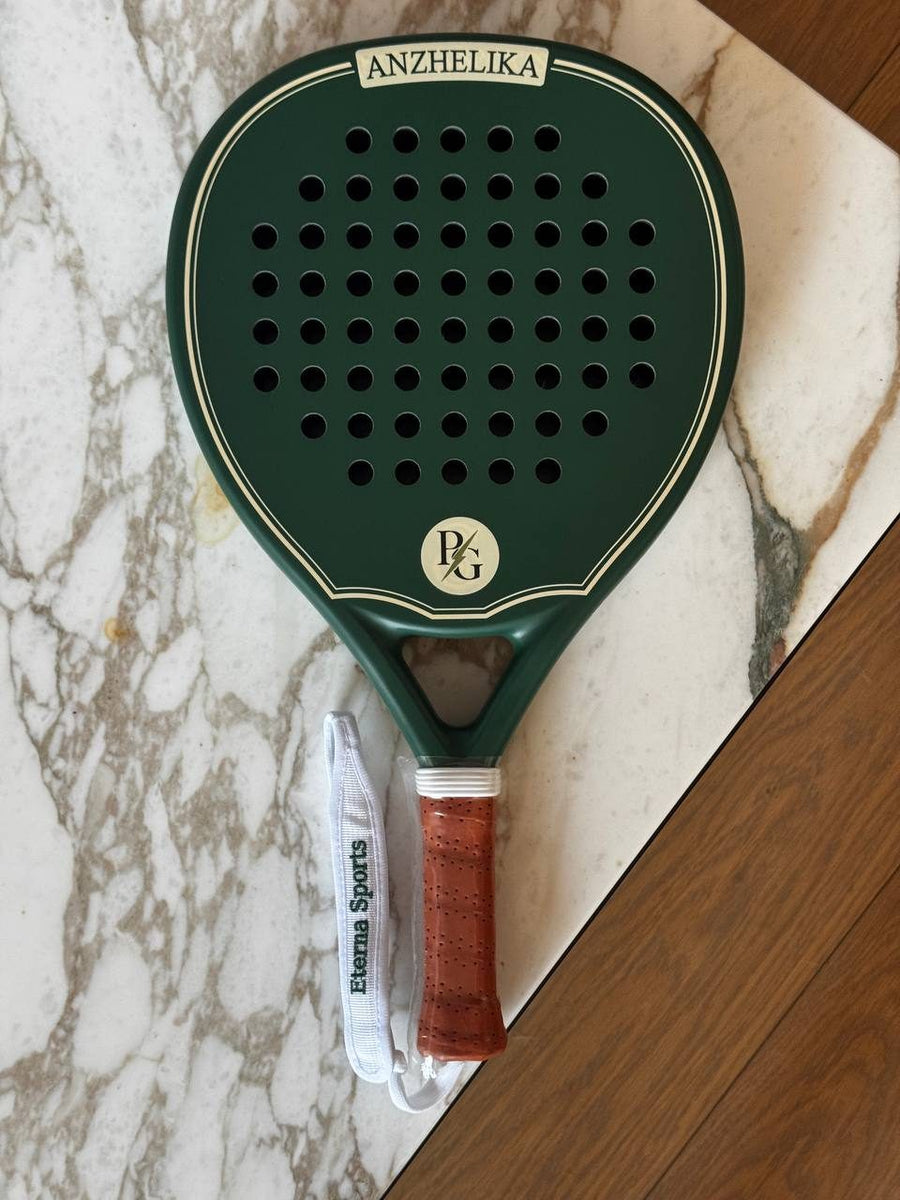 Green Eterna Sports racket engraved with a name and personal initials, on marble