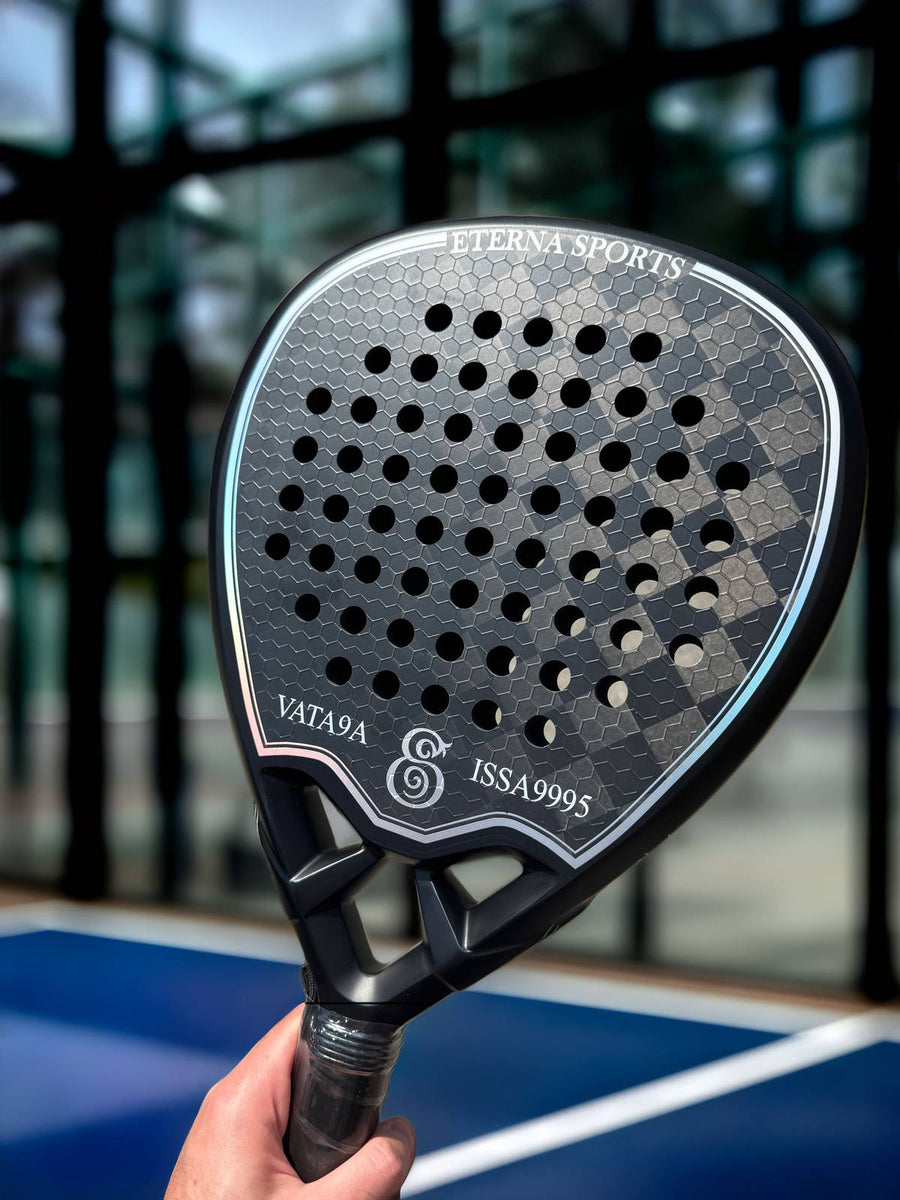 Personalised name engraving on a black Eterna Sports racket, held up on a padel court