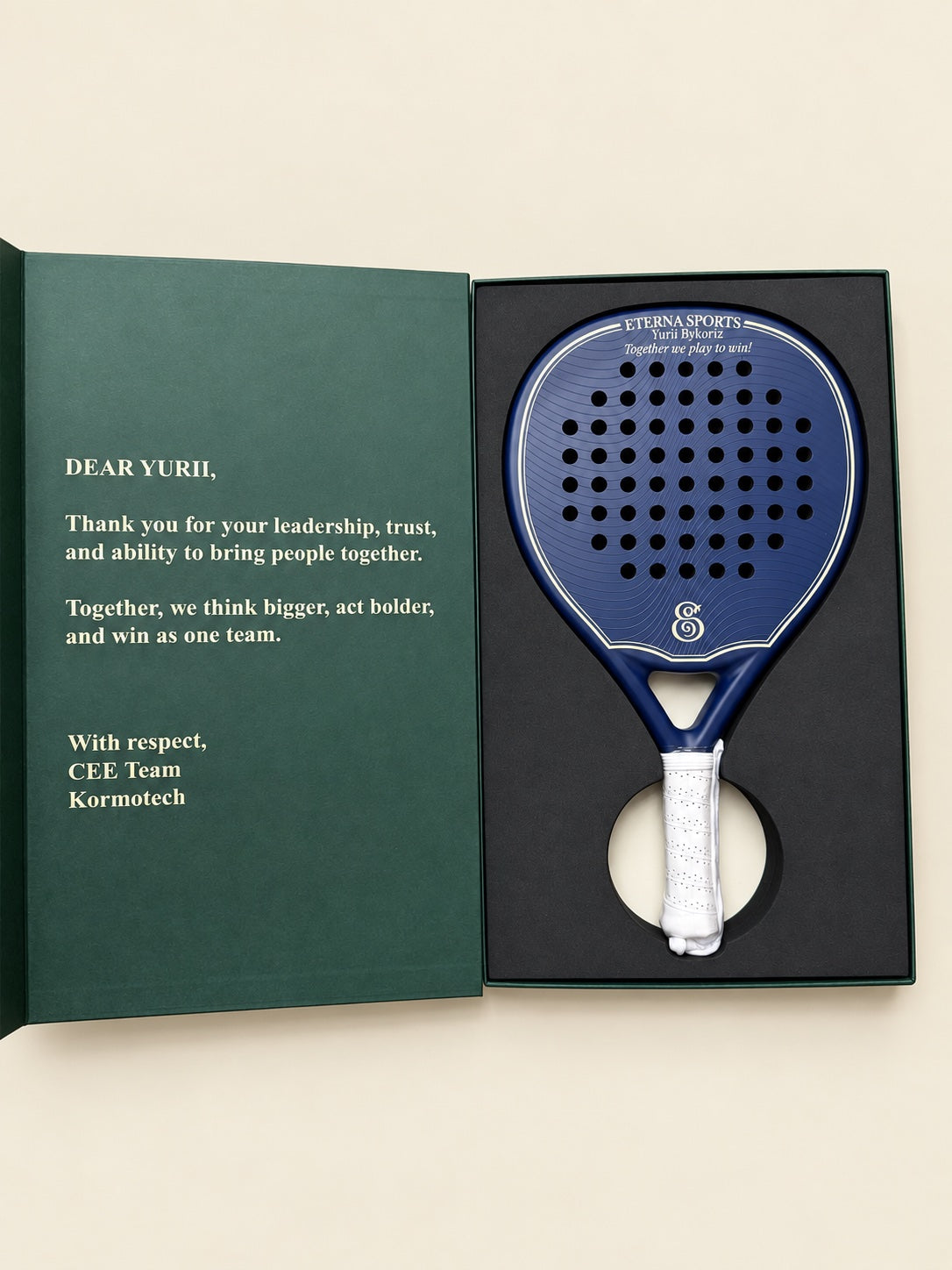 Blue Eterna padel racket in an open gift box with engraving and a message from the team.